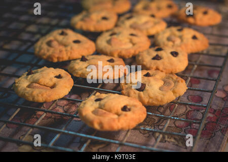 In casa biscotti al burro con scaglie di cioccolato e anacardi (cattura da illuminazione calda in cucina e soft focus) Foto Stock