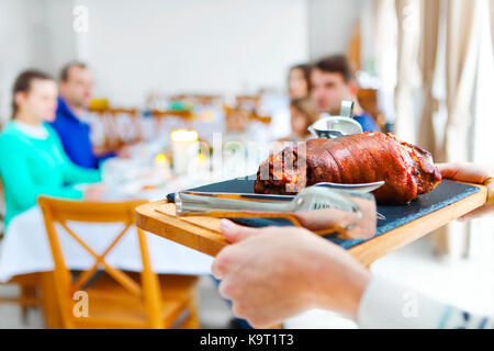 Happy amici seduti attorno a un tavolo e godersi la cena di Natale insieme Foto Stock