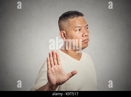 Closeup ritratto burbero uomo di mezza età con cattivo atteggiamento dando parlare a mano gesto con il palmo verso l'esterno isolato muro grigio Sfondo. emotio negativa Foto Stock