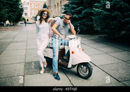 Bella giovane seduto su uno scooter insieme nella strada di città Foto Stock