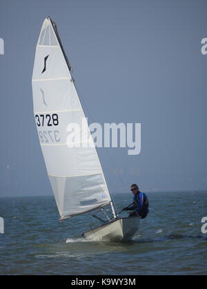 Un assolo di vela classe dinghy in una giornata di sole. Foto Stock