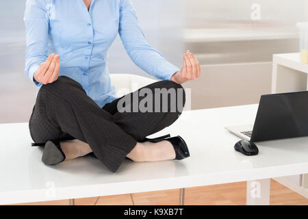 Close-up di imprenditrice fare yoga in ufficio Foto Stock