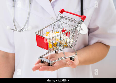 Close-up di medico donna azienda carrello con piena di pillole Foto Stock