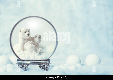 Snow Globe su un antico argento stand in caduta di neve per le vacanze di natale con orso polare figura Foto Stock