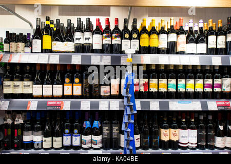 Bottiglie di vino rosso sul display su uno scaffale di supermercato. Foto Stock