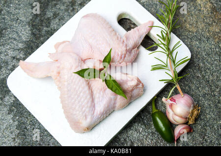 Materie di ali di pollo con rosmarino pronti per la cottura Foto Stock