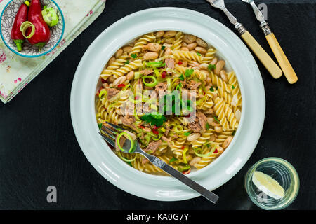 Pasta con tonno, fagioli bianchi e porri guarnite con prezzemolo fresco - elevato angolo di visione Foto Stock