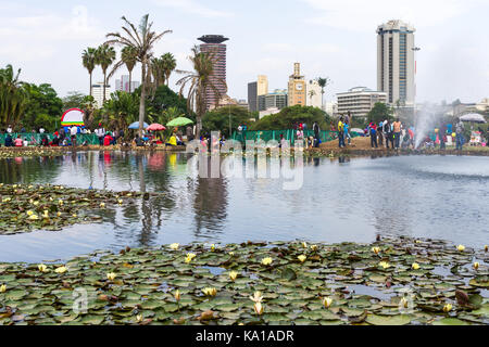 Lily lago con persone camminando per la città gli edifici possono essere visti sullo sfondo, Uhuru Park, Nairobi, Kenya, Africa orientale Foto Stock