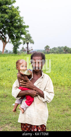 Angul, odisha, India - 3 agosto 2017: un uomo che porta il suo bambino in un villaggio a angul distretto di odisha stato in India. Foto Stock