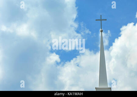 Croce, sul campanile, è incorniciato da nuvole bianche e blu del cielo. Foto Stock
