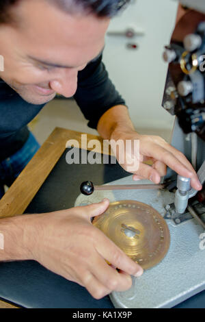 Gioielliere lavorando su metalli con dispositivo ottico Foto Stock