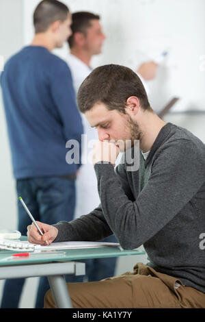 Agli studenti di prendere appunti in classe in alta scuola Foto Stock