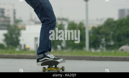 Close up di un skateboarders piedi mentre pattinaggio su calcestruzzo a skate park Foto Stock