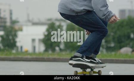 Close up di un skateboarders piedi mentre pattinaggio su calcestruzzo a skate park Foto Stock