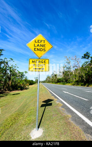 Cartello stradale "corsia di sinistra termina, immettersi a destra', sulla costa di Whitsunday, Queensland, QLD, Australia Foto Stock