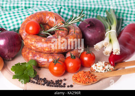 Materie salsicce fatte in casa con verdura e spezie sul tavolo. copia spazio. salsiccia fresca con cipolle, paprika, paradise, rosmarino e aneto pronto per c Foto Stock