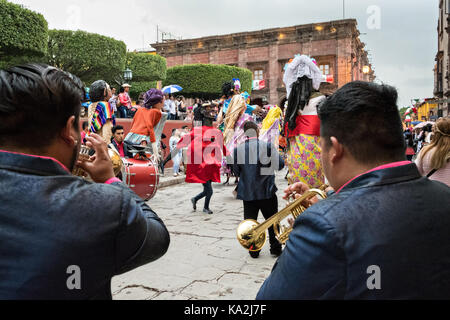 Una Marching Band segue una sfilata di carta gigante-mache marionette chiamato mojigangas in una processione attraverso la città all'inizio della settimana di festa del patrono san michele settembre 22, 2017 in San Miguel De Allende, Messico. Foto Stock