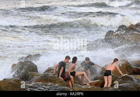 Ponce Inlet, Stati Uniti. 24Sep, 2017. colby savary (l), Natalie Thomas David Thomas e madelyn miller colpiti dal surf come onde infrangersi sulle rocce il 24 settembre 2017 in Ponce Inlet, Florida come uragano maria aratri fino alla costa atlantica portando alte onde e correnti di rip dopo aver effettuato un colpo diretto a puerto rico, lasciando tutta l isola senza elettricità. Credito: Paul Hennessy/alamy live news Foto Stock