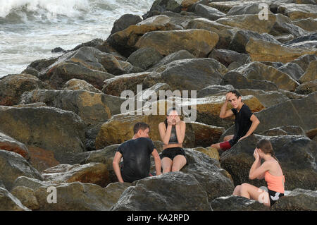 Ponce Inlet, Stati Uniti. 24Sep, 2017. colby savary (l), Natalie Thomas David Thomas e madelyn miller asciugare i loro occhi dopo essere colpito da surf come onde infrangersi sulle rocce il 24 settembre 2017 in Ponce Inlet, Florida come uragano maria aratri fino alla costa atlantica portando alte onde e correnti di rip dopo aver effettuato un colpo diretto a puerto rico, lasciando tutta l isola senza elettricità. Credito: Paul Hennessy/alamy live news Foto Stock