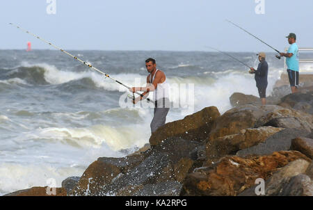 Ponce Inlet, Stati Uniti. 24Sep, 2017. Gli uomini pesce dal molo come onde infrangersi sulle rocce il 24 settembre 2017 in Ponce Inlet, Florida come uragano maria aratri fino alla costa atlantica portando alte onde e correnti di rip dopo aver effettuato un colpo diretto a puerto rico, lasciando tutta l isola senza elettricità. Credito: Paul Hennessy/alamy live news Foto Stock