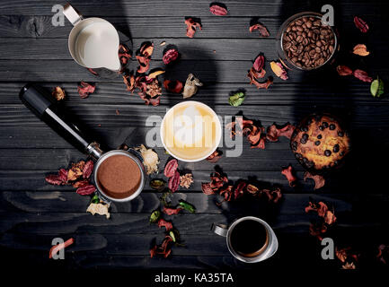 Caffè con dolci su un nero lo sfondo di legno Foto Stock