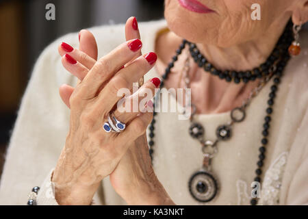 Senior donna di lusso con manicure. luxury vecchia donna con unghie di rosso e argento elegante anello. womens cura e benessere. Foto Stock