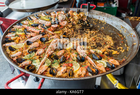 Grande padella con pesce paella cibo su fuoco di riscaldamento per i turisti a comprare e mangiare a Bergen Norvegia Foto Stock