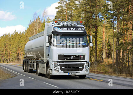 Salo, Finlandia - 21 aprile 2017: bianco volvo fh semi autobotte dalla Polonia trasporta merci lungo la strada rurale a molla nel sud della Finlandia. Foto Stock