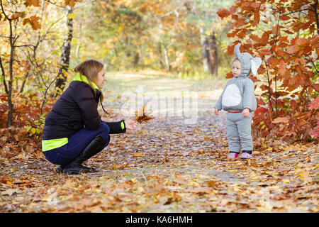 Giovane donna e bambina vestito in costume dell'elefante a giocare nel parco di autunno Foto Stock