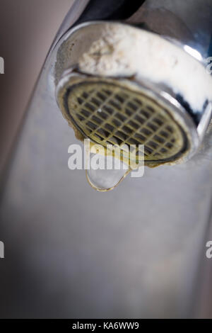 Il vecchio perde il rubinetto con pietra e sedimenti di calcio a causa di acqua dura. Foto Stock