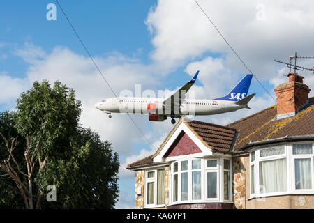 Jet in arrivo a terra come sorvolare case su Myrtle Avenue, a Hounslow, prima di atterrare all'aeroporto di Heathrow, terminale 4. Foto Stock