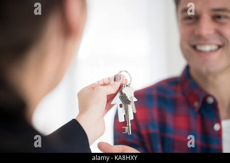 L'uomo raccogliendo le chiavi di casa nuova da agente immobiliare femmina Foto Stock