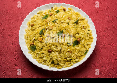 Indian tradizionale e popolare stuzzichino poha chivda o chivada realizzato da friggere gli elementi come sottile appiattito riso, peperoncino rosso, foglie di curry, arachidi, contanti Foto Stock