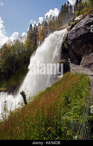 Steinsdalsfossen cascata nel fiume di Steine, paesaggio scenico con cascata circondata da montagne e rocce Foto Stock
