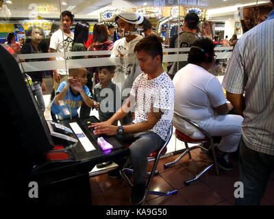 Mandaluyong city, Filippine - 24 settembre 2017: i giocatori all'interno di un video gioco arcade. Foto Stock