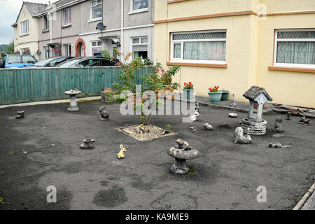 La Tarmac pavimentato giardino anteriore che colpiscono il drenaggio delle acque con calcestruzzo ornamentali in figure di animali al di fuori di casa in Galles UK KATHY DEWITT Foto Stock