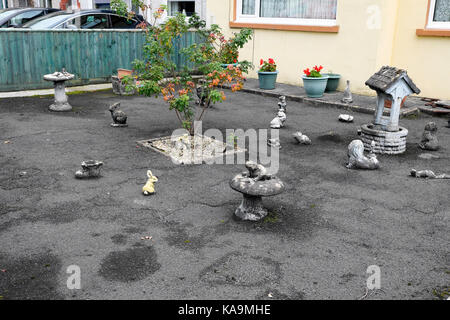 La Tarmac pavimentato giardino anteriore che colpiscono il drenaggio delle acque con calcestruzzo ornamentali in figure di animali al di fuori di casa in Galles UK KATHY DEWITT Foto Stock