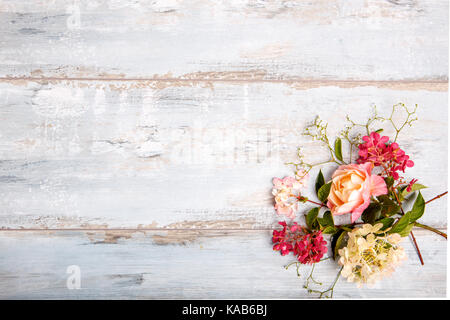 Festosa composizione floreale in bianco sullo sfondo di legno. vista aerea. Foto Stock
