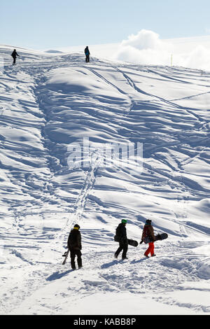 Gli appassionati di snowboard andare sul sentiero nella neve a sun fredda mattina il Caucaso le montagne in inverno, georgia, regione gudauri. Foto Stock