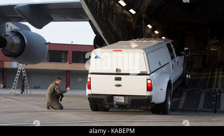 Airman 1. Classe Logan Smith, 3d Airlift Squadron loadmaster, martials una Ford F-450 pickup truck come si ritira un C-17 Globemaster III, Sett. 24 Foto Stock
