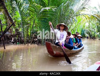 Donna vietnamita remare una barca nel fiume Mekong in Vietnam Foto Stock