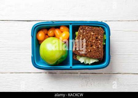 Foto di sport utile uno snack nel contenitore bianco sul tavolo di legno Foto Stock