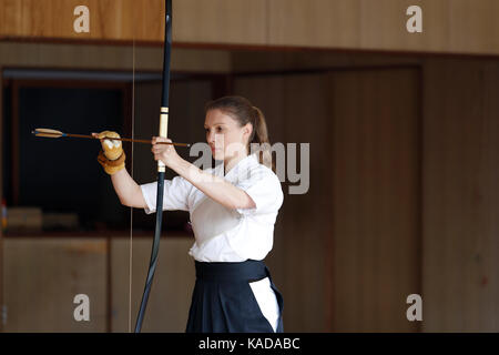 La donna caucasica la pratica tradizionale giapponese Kyudo tiro con l'arco Foto Stock