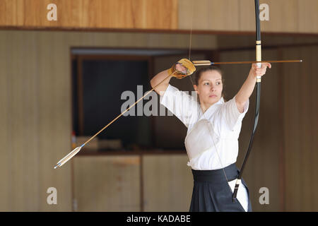 La donna caucasica la pratica tradizionale giapponese Kyudo tiro con l'arco Foto Stock