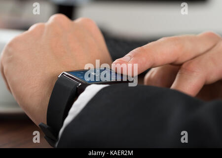 Close-up di un imprenditore di controllo sul tempo di smartwatch Foto Stock