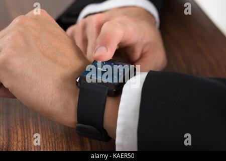 Close-up di un imprenditore controllo ora sull'orologio da polso Foto Stock