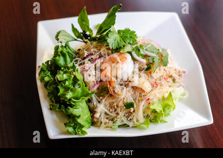 Yum woonsen vetro insalata di tagliatella, vetro tagliatelle insalata servita su un letto di lattuga con pollo e gamberetti. Foto Stock