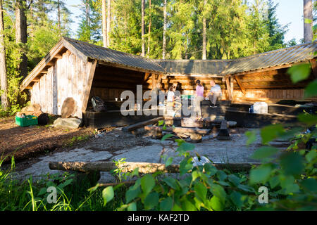 Gli amici di preparare alimenti by shed in foresta Foto Stock