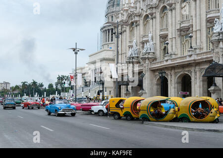 Taxi attendere dal lato della strada nel Parque Central come auto d'epoca passare da a l'Avana, Cuba. Foto Stock