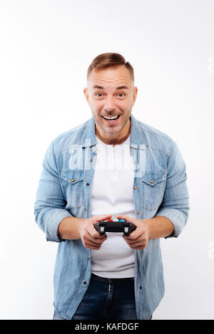 Entusiastico uomo giovane la riproduzione di video gioco Foto Stock